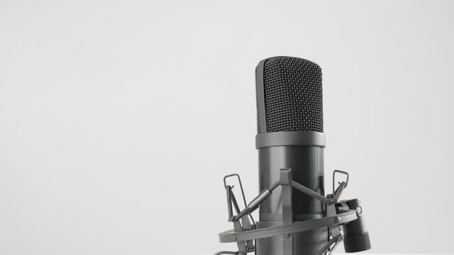 Professional microphone is spinning on a white background. Copy space