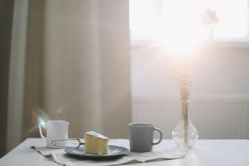 Morning breakfast with a piece of fresh homemade cake, pitcher and cup of coffee on a table