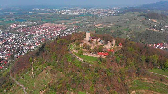 Beautiful top view of the Starkenburg castle in the German city of Heppenheim. The castle is high on the mountain. Mountains and the blue sky in the background. Tiled roofs of houses.