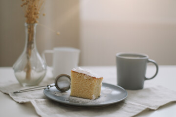 Morning breakfast with a piece of fresh homemade cake, pitcher and cup of coffee on a table