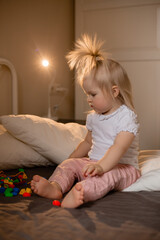 Naklejka premium A little girl is in bed at home. Happy Baby At Home