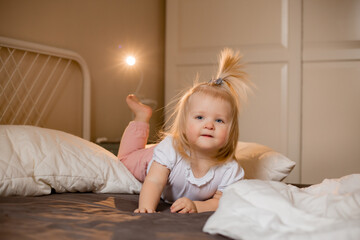 Fototapeta premium Happy little girl pragy in bed at home