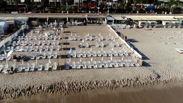 Low altitude aerial view of deckchairs are folding chairs usually with a frame of treated wood or other material and meant for leisure at the beach sun tanning and relaxing on vacation 4k quality