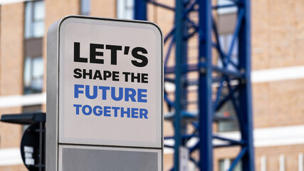 Let's Shape The Future Together sign in a city setting under construction
