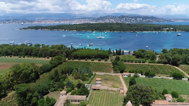 Aerial view of Ile Saint Honorat is the second largest of the L&eacute;rins Islands about a mile off shore from the French Riviera town of Cannes in the background also showing Sainte Marguerite 4k quality