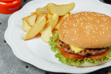 hamburger with fries and salad on the plate