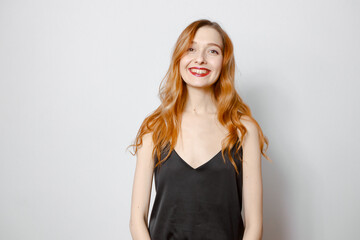 A red-haired girl with long hair in a black blouse smiles. White background