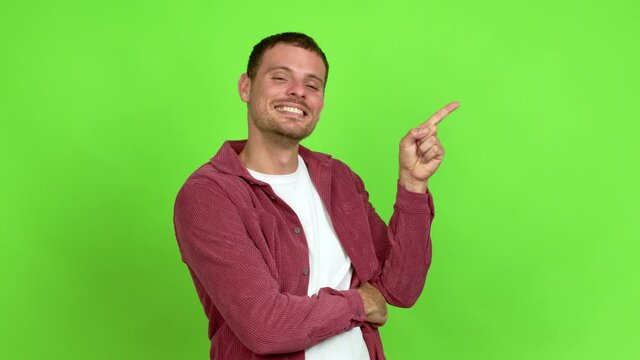 Brazilian handsome man pointing finger to the side and presenting a product over isolated background