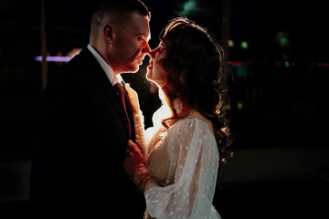 profiles of the bride and groom in the dark in a counter-light.