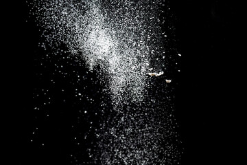 White powder explosion. White powder splash isolated on black background. Flour sifting on a dark background. Explosive powder white