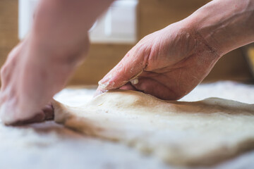Rolling traditional dough in the kitchen, close up