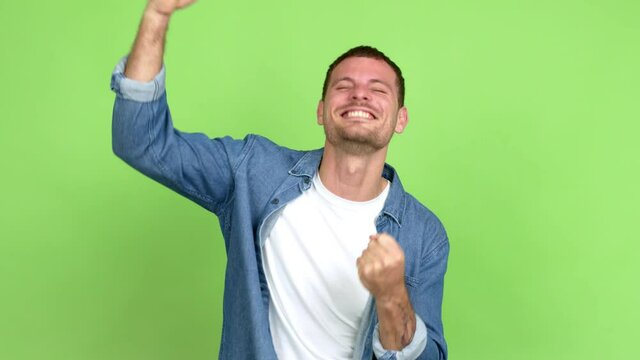 Brazilian handsome man celebrating a victory and surprised to be successful over isolated background