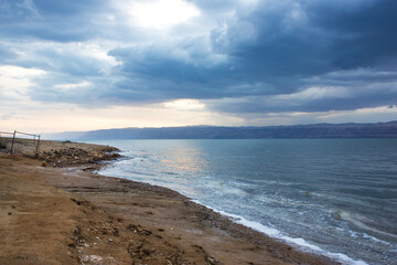 Deserted shore of Dead sea on Jordanian side in off-season, view of Israel, beach is closed during coronavirus infection, COVID-19.