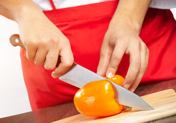 Chef hands cutting red fresh pepper