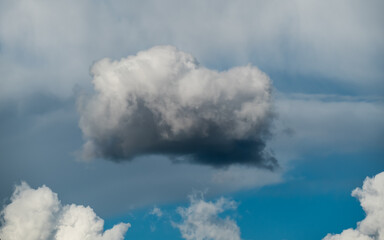 Lone fluffy cloud in blue sky