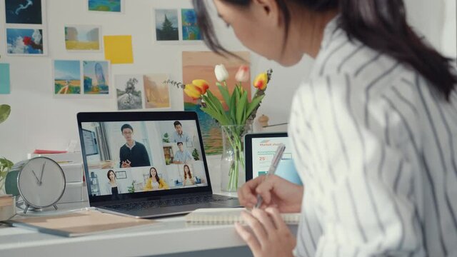 Young asia female employee listen leader on video call with diverse multiracial colleagues on online with laptop at home. Distance learning. Girl student learn online at house, Online meeting concept.
