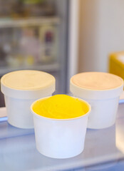 Obraz na płótnie Canvas Yuzu and mandarin orange Italy Gelato ice cream iced dessert in a plastic cup.