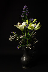 Stillife with white lily flowers and a black backgound