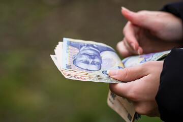 Selective focus on detail of LEI banknotes. Counting or giving Romanian LEI banknotes. World money concept, inflation and economy concept