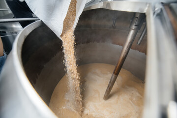 The process of filling malt in a container for making beer. Traditional brewing.