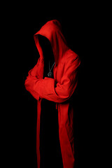 Mystery man in a red hooded cloak in the dark. Unrecognizable person. Hiding face in shadow.Ghostly figure. Sectarian. Conspiracy concept. - 430856432