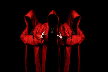 Mystery three sectarians in a red hooded cloaks in the dark. Unrecognizable person. Hiding face in shadow. Conspiracy concept.
