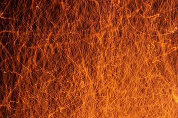 Incandescent sparks from the fire on a black background