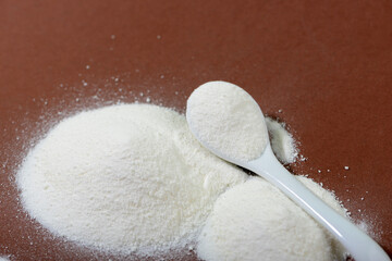 Collagen powder on brown background.