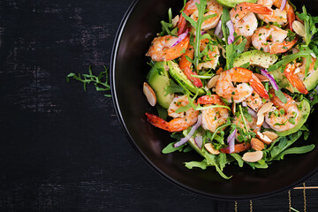 Salad of prawns. Salad of shrimps, arugula, avocado slice, red onion and almond nuts. Healthy concept. Top view, overhead