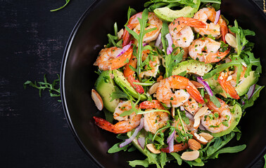 Salad of prawns. Salad of shrimps, arugula, avocado slice, red onion and almond nuts. Healthy concept. Top view, overhead