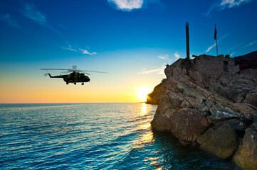 Sunset on the sea with helicopter silhouette © unclepodger
