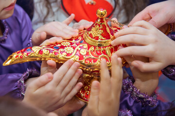 Golden Red Old magic lamp . They touch the old magic lamp with their hands .