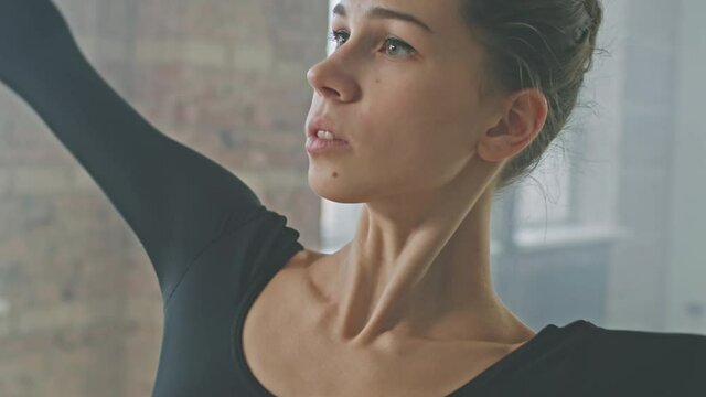 Close up of young sensual woman with beautiful collarbones dancing ballet alone in choreography class