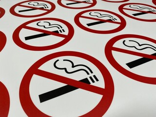 Red tobacco smoke ban sticker on a white background in a printing house