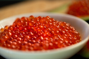 Red caviar in a white cup close-up. Selective focus. The concept of healthy food