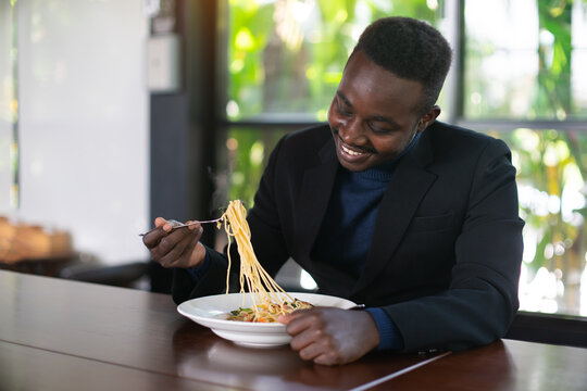 African businessman having a happy lunch with eating Spaghetti in restaurant