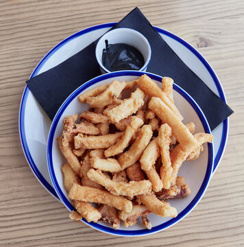 Plate of typical food of Spain. Rabas , breaded squid
, from Santander, Cantabria, Spain, accompanied by black squid sauce