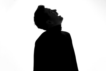 Silhouette of young man looking up being excited.