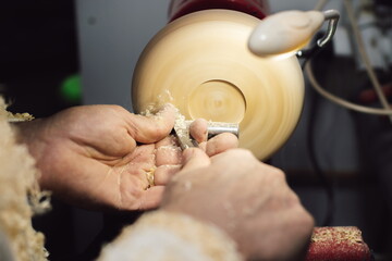 Joinery worker shaping a piece of wood on the lathe