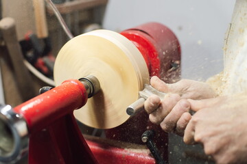 Joinery worker shaping a piece of wood on the lathe