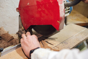 Cabinetmaker hands cutting wood with electric saw