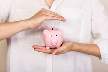 Piggy bank in hand on light  background, space for text. Finance, saving money. Business to success and saving for retirement concept