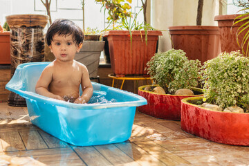 Cute baby boy enjoying bathing in bathtub