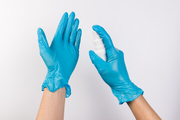Health protection equipment such as gloves and sanitizer held in hands, isolated on white background