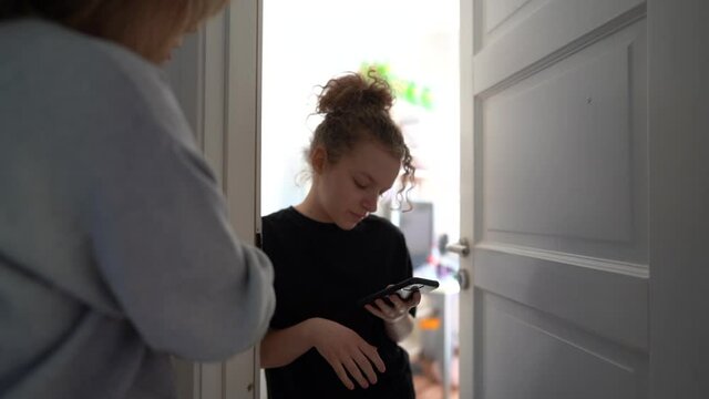 Conflict between mother and teenage daughter. The mother tries to talk to the girl. My daughter is distracted by her smartphone, Internet addiction. Teenager at her room