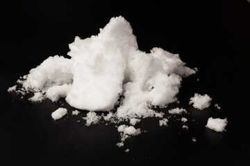 Heap of white snow on black background.The structure of snow and ice. Close-up.