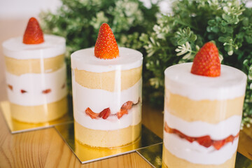 Strawberry shortcakes with whipped cream and fresh berries on wooden table