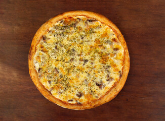 Top view of whole pizza of meat or rump or filet, on wooden table