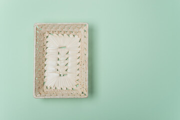 Rectangular empty wicker straw basket on light green background. View from above. Decorative interior items. Copy space