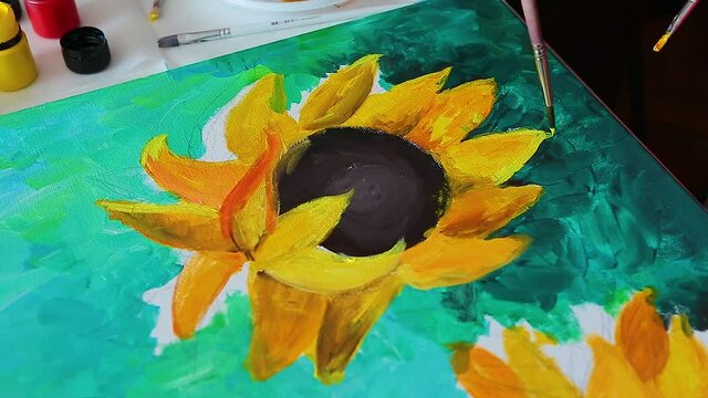  A hand with brush drawing picture of sunflowers by acrylic paints on canvas. Art concept.